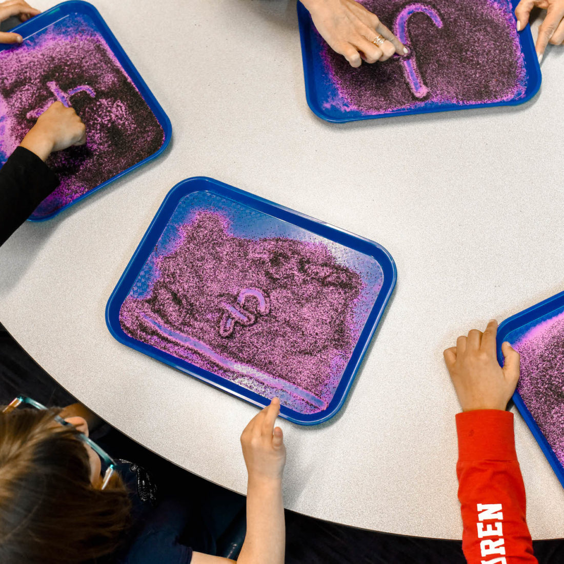 Students using sand in multisensory learning